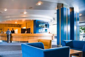 eine Lobby eines Restaurants mit blauen Stühlen in der Unterkunft Baltic Zinnowitz - Hotel mit Meerwasserpool und Thermalbad in Zinnowitz + 37 Fotos