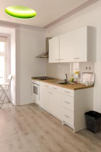 a kitchen with white cabinets and a green frisbee at Inn-Chiado Restauradores Prime Suites in Lisbon