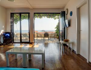 Sala de estar con mesa y vistas al océano en Apartments Minja Nerin, en Petrovac na Moru