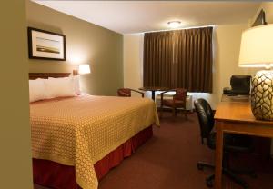 a hotel room with a bed and a desk at Marina Inn & Suites Chalmette-New Orleans in Chalmette