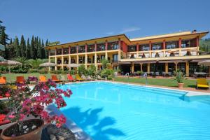un hotel con piscina di fronte a un edificio di Villa Madrina Lovely and Dynamic Hotel a Garda