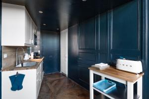 a kitchen with blue walls and a counter with a sink at Apartment Le 1727 in Saint Malo +33 photos