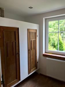 una habitación vacía con dos puertas y una ventana en Apartamenty Sudeckie nad zalewem, en Sosnówka