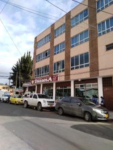 eine Gruppe von Autos, die vor einem Gebäude geparkt sind in der Unterkunft Habitación 5 minutos aeropuerto in Bogotá