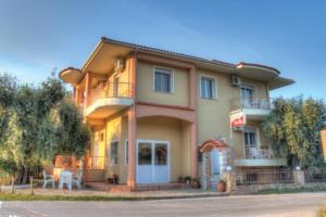 a large house with a balcony and a table at Studios Stella in Skala Potamias