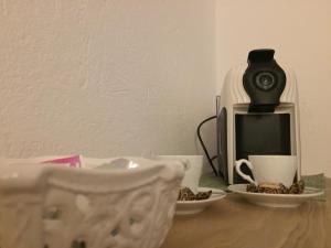 ein Tisch mit zwei Tassen und einer Kaffeemaschine in der Unterkunft La Masca in Gaiola