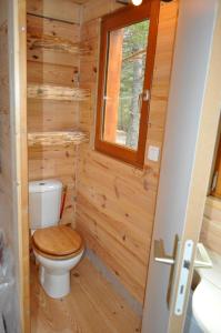 a bathroom with a toilet in a wooden wall at Cabane des Guernazelles in Valderoure