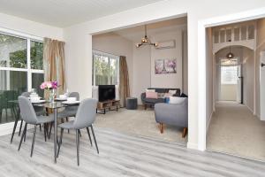 a dining room and living room with a table and chairs at Albemarle Villa - Christchurch Holiday Homes in Christchurch