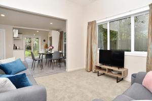 a living room with a couch and a flat screen tv at Albemarle Villa - Christchurch Holiday Homes in Christchurch