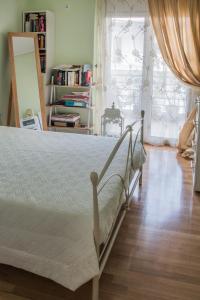 um quarto com uma cama, piso em madeira e uma janela em Artemis central apartment em Kórinthos