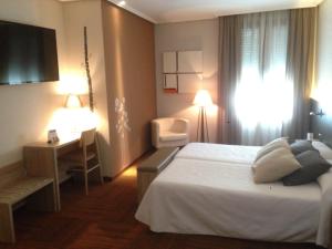 a hotel room with a bed and a desk at Hotel Oriente in Teruel