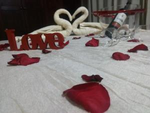 a bed with red roses and two swans and the word liar at Pousada Casa Recanto da Serra in Petrópolis +58 photos
