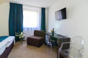 a hotel room with a desk and a bed and a bedroom at PENZION POD ZÁMKEM in Valtice