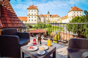 a table with food and drinks on a balcony with buildings at PENZION POD ZÁMKEM in Valtice