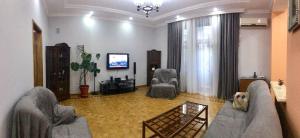 a living room with two couches and a flat screen tv at Calm center of Baku in Baku