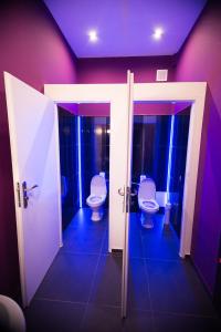 a bathroom with two toilets and purple walls at Greg&Tom Beer House Hostel in Krakow