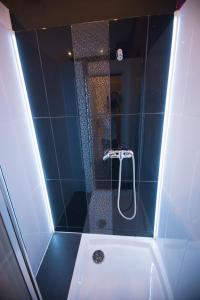 a bathroom with a shower with a white bath tub at Greg&Tom Beer House Hostel in Krakow