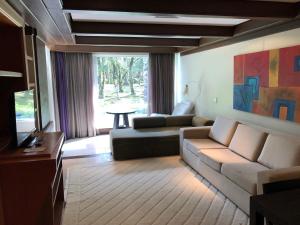 sala de estar con sofá y TV en Flat Luxo Mountain Village, en Canela