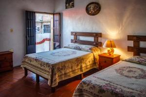 a bedroom with two beds and a lamp and a window at Villa San Francisco Hotel in Taxco de Alarcón +32 photos