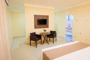 ROYAL Hotel & Gastronomia في ماكابا: غرفة مع طاولة وكراسي وسرير