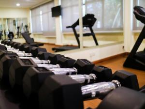 un gimnasio con filas de pesas en una habitación en StarLodge en Kampong Jerudong