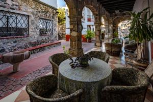 a table and chairs in a room with a building at Villa San Francisco Hotel in Taxco de Alarcón