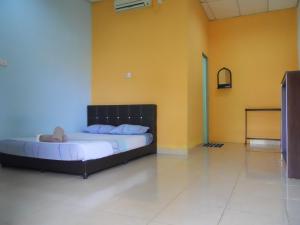 a bedroom with two beds in a room with yellow walls at Rainbow Lodge in Pantai Cenang