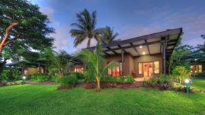 a house with palm trees in front of a yard at Paradise Resort Taveuni in Waiyevo