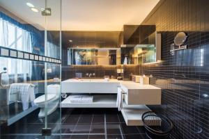 a bathroom with a tub and a sink and a toilet at Hotel Soul Suzhou in Suzhou