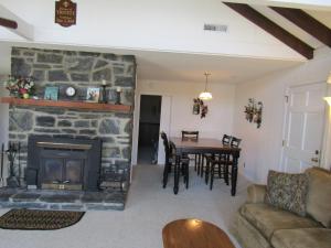 a living room with a stone fireplace and a table at Sugar Mountain Drive 1866 Home in Sugar Mountain