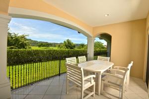 a patio with a table and chairs and a fence at Los Suenos Resort Colina 5E two bedroom by Stay in CR in Herradura