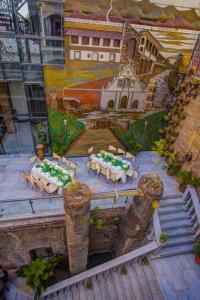 a painting of a patio with tables and chairs at Hotel Luna in Vigan