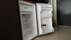 an empty refrigerator with its door open in a kitchen at Apartasuites Medellin Los Molinos in Medellín