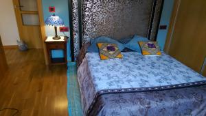 Una cama con sábanas azules y almohadas en un dormitorio en Apartamento San Antonio, en Sedaví
