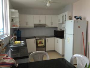 a kitchen with white cabinets and a white refrigerator at Departamento Tonsupa piso 11 in Tonsupa