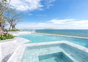 a beach with a pool and a balcony overlooking the ocean at U Jomtien Pattaya - SHA Extra Plus in Jomtien Beach