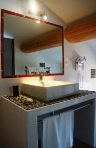 een badkamer met een wastafel en een spiegel bij Hotel Le Saint Jean in Ersa
