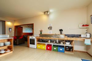 
a kitchen with a stove, sink, cabinets and a refrigerator at Dolphin Lodge in Kaikoura
