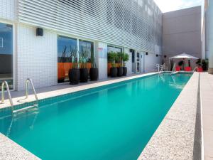 uma piscina em frente a um edifício em Novotel Santos Gonzaga em Santos
