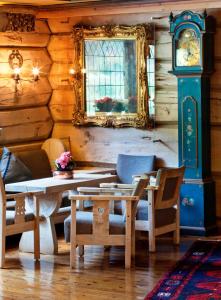 a dining room with a table and a grandfather clock at Elveseter Hotell in Boverdalen