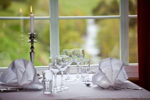 a table with wine glasses and a candle on it at Elveseter Hotell in Boverdalen