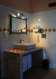 a bathroom with a sink and a mirror at Hotel Le Saint Jean in Ersa
