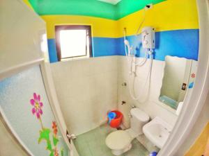 a small bathroom with a toilet and a sink at Tagaytay Bloom Breeze Cruz Apartelle in Tagaytay
