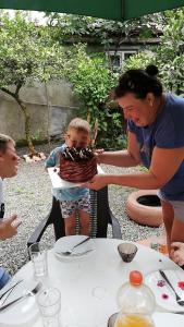 a woman holding a baby in front of a cake at Apartment MaxinJauri in Makhinjauri