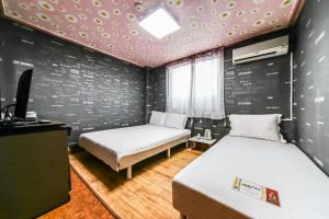 two beds in a room with a wall with polka dots at Mirim Motel in Gyeongju