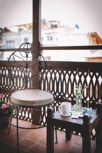 a table and a chair on a balcony with a coffee cup at Hotel Patan House in Pātan
