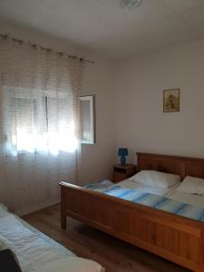 a bedroom with two beds and a window at Apartman Nicolle in Krk