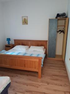 a bedroom with a wooden bed and a mirror at Apartman Nicolle in Krk