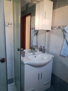 a bathroom with a white sink and a shower at Apartman Nicolle in Krk