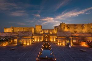 um grande edifício com uma fonte em frente em Suryagarh Jaisalmer em Jaisalmer